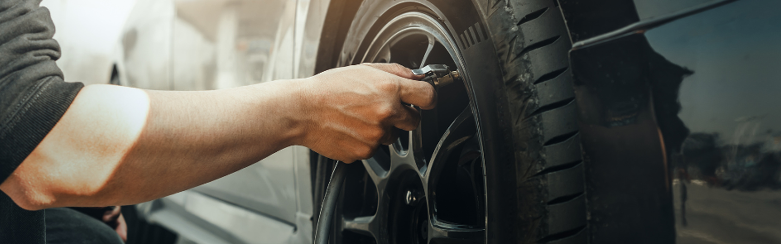 A person putting air on their car tire
